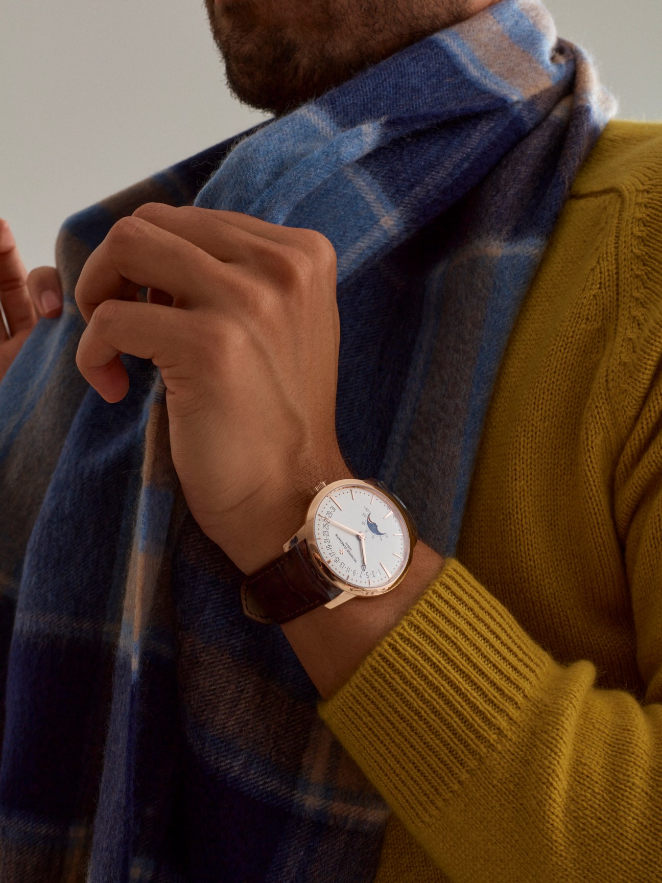 Man wearing Vacheron Constantin moon phase retrograde date watch with Boglioli rollneck jumper and Begg & Co scarf.