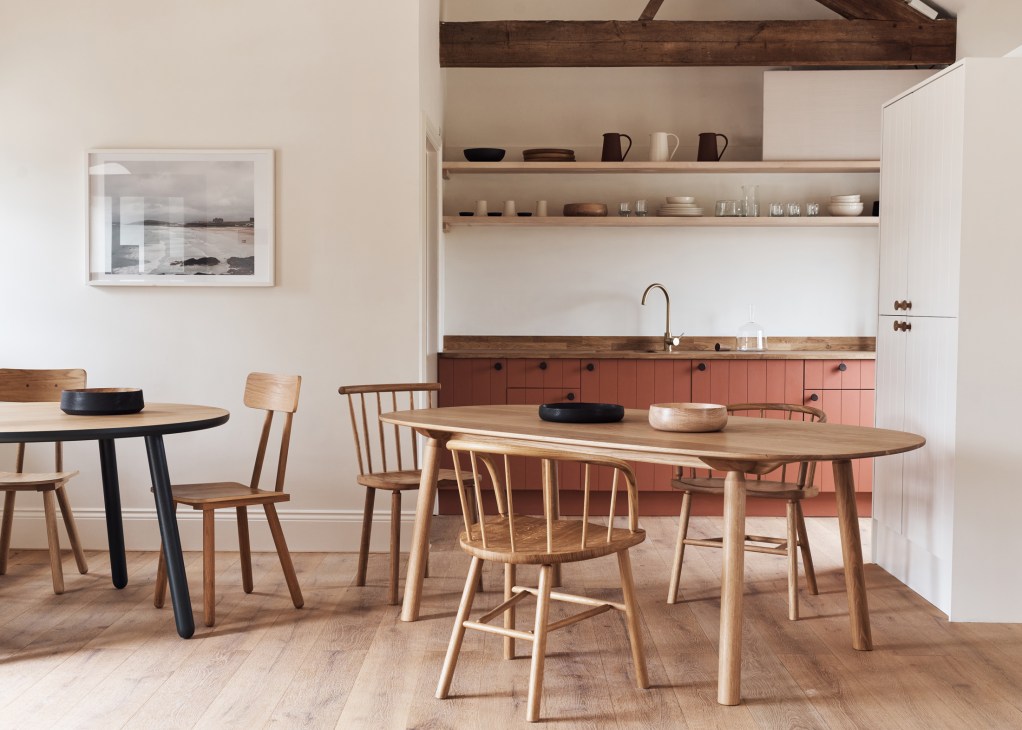 Another Country showroom interior in converted barn with wooden furniture displays and exposed ceiling beams