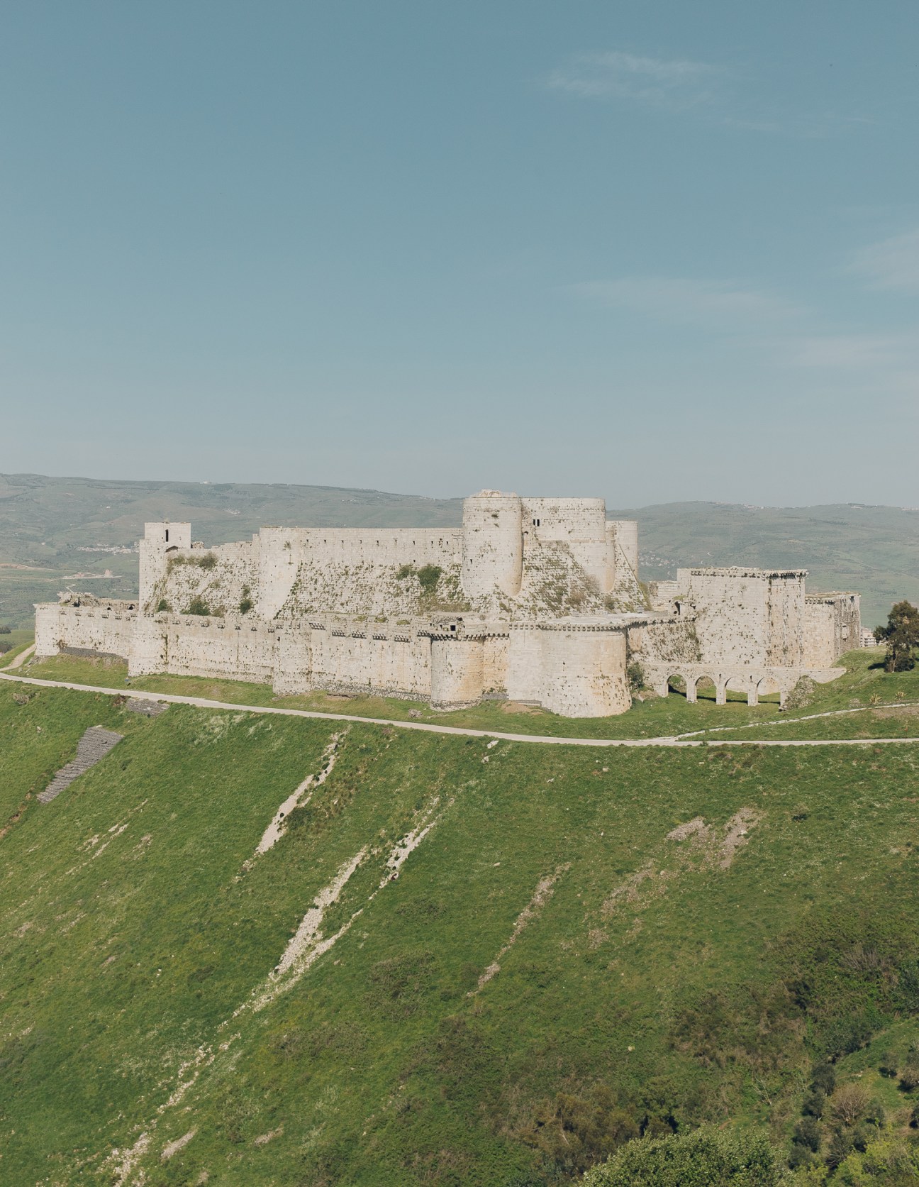 Medieval Krak des Chevaliers castle fortress situated on a hilltop with stone walls and towers
