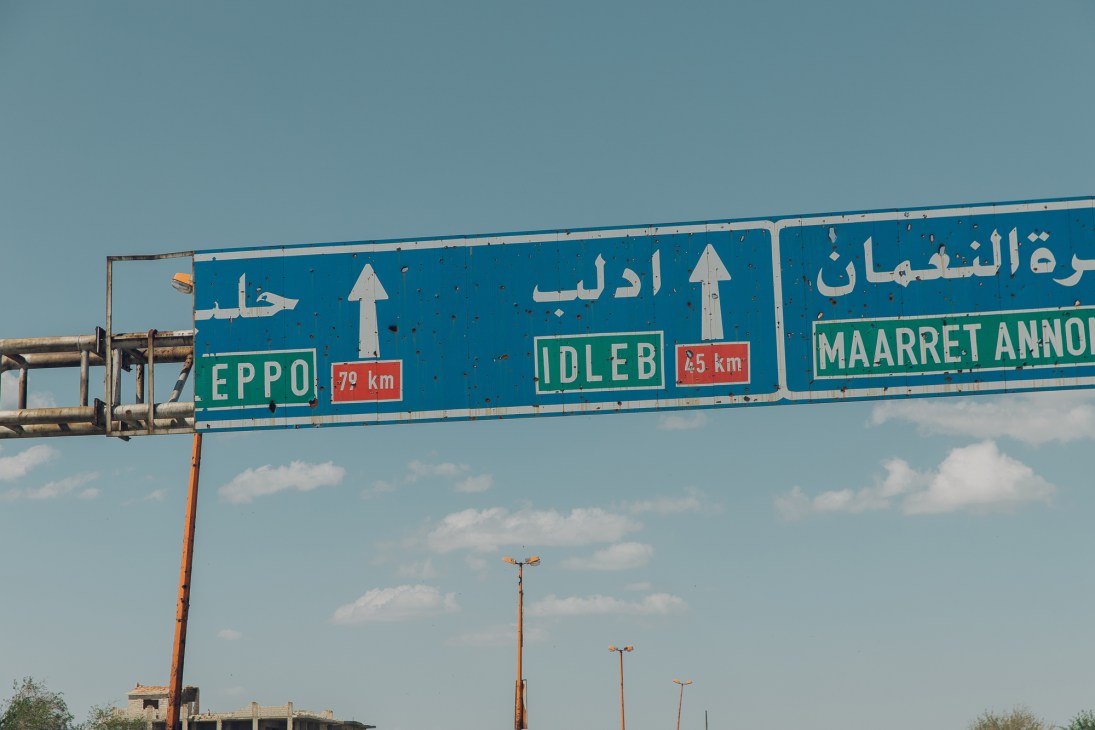 Highway road sign in Arabic and English showing directions to Eppo 79km, Idleb 25km and Maaret Annouman