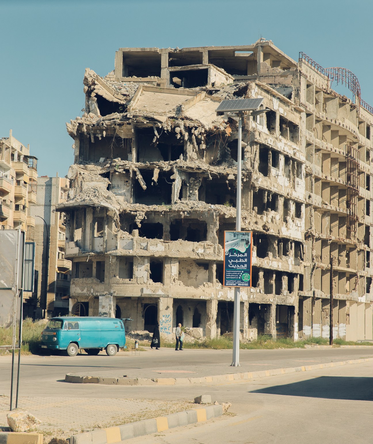 Severely damaged multi-story concrete building with exposed interior and structural damage from war