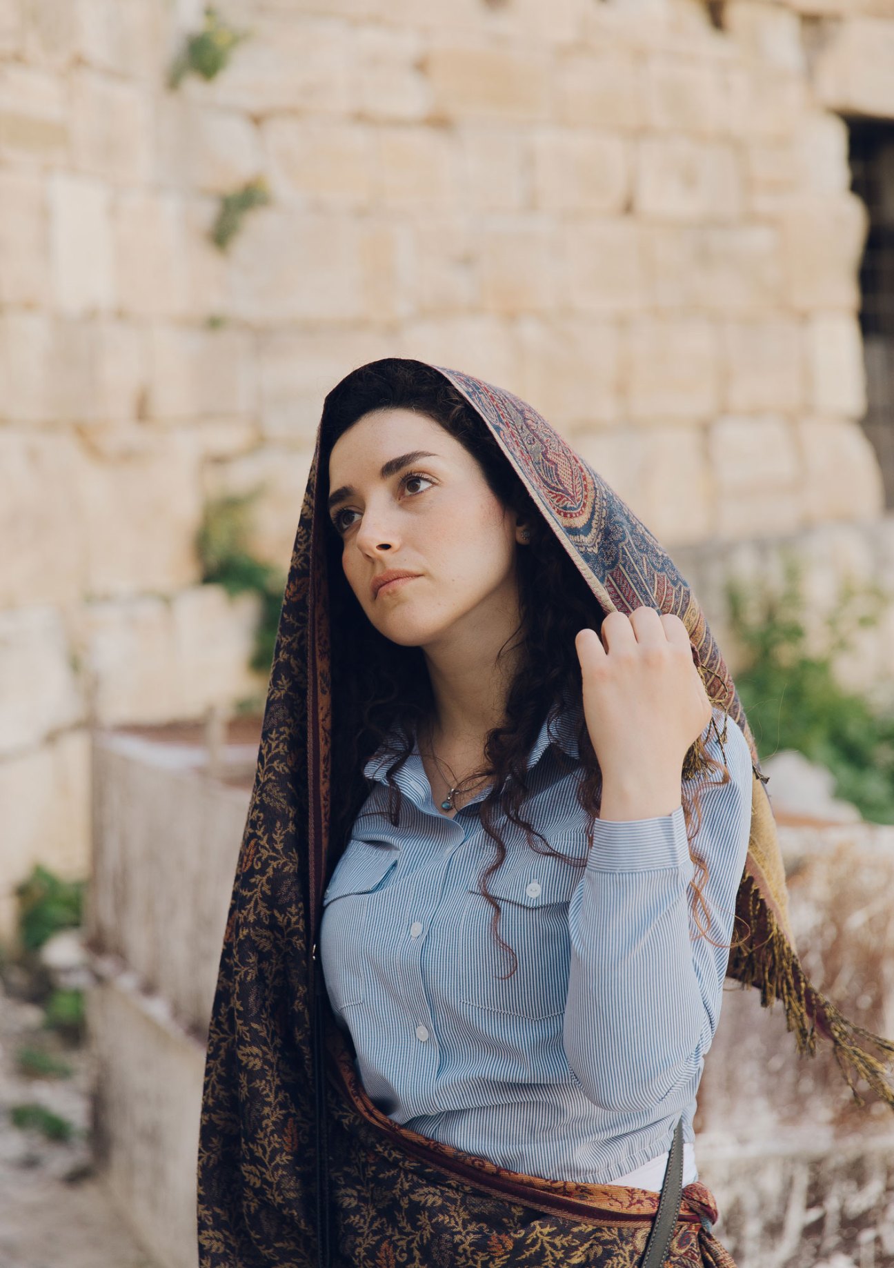 Tour guide Arwa Haddad wearing a patterned headscarf and blue striped shirt in Damascus