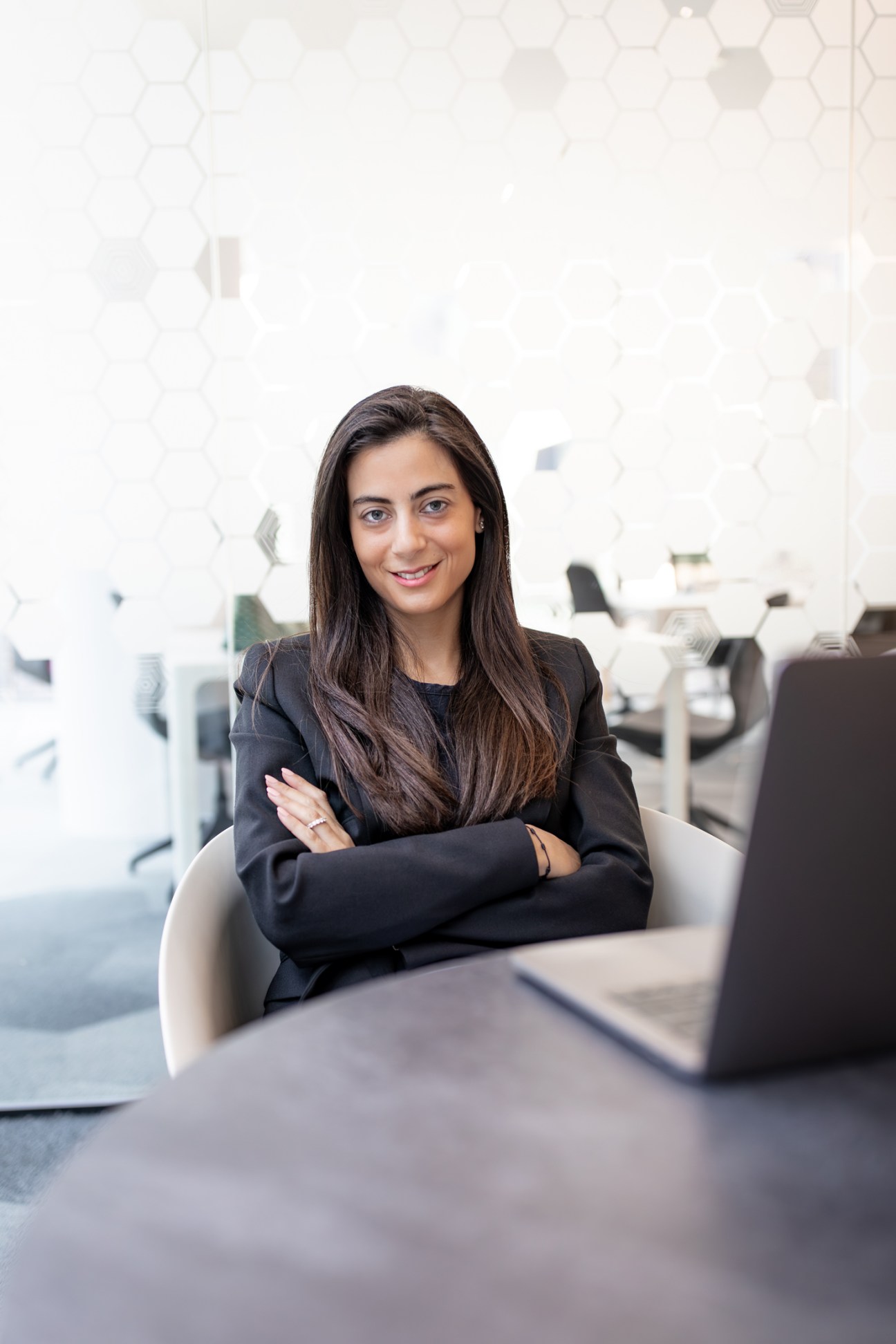 Audrey Nakad, founder of Ostaz, sitting at a desk in a modern office with arms crossed.