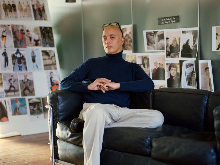 Lawrence Steele wearing a rollneck and white canvas trousers in the Aspesi showroom in Milan