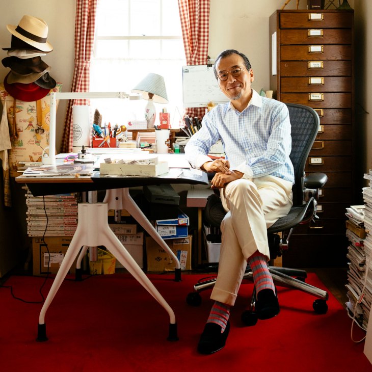 Hiroshi Watatani sitting at his desk in his Tokyo studio workspace with art supplies and storage drawers