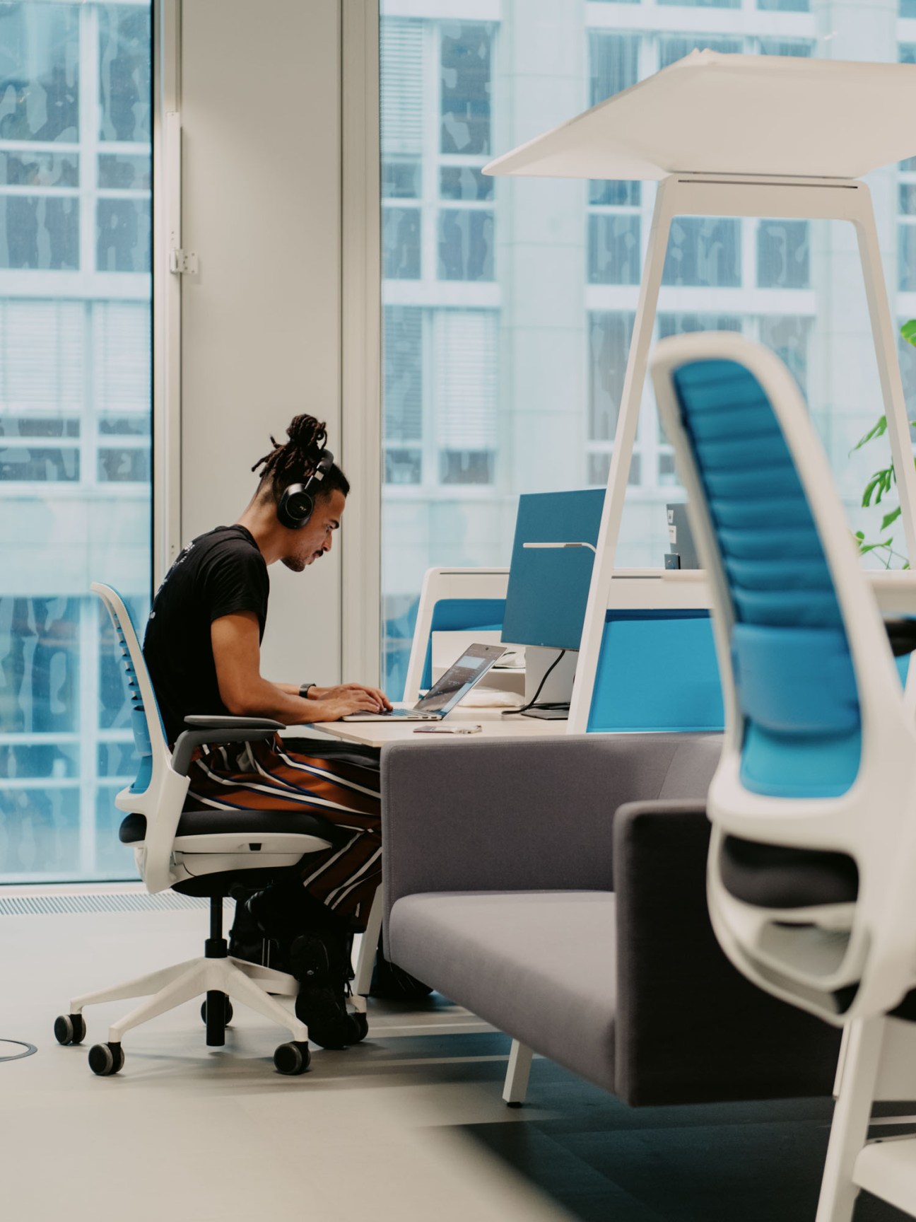 Person working focused at laptop in modern co-working space