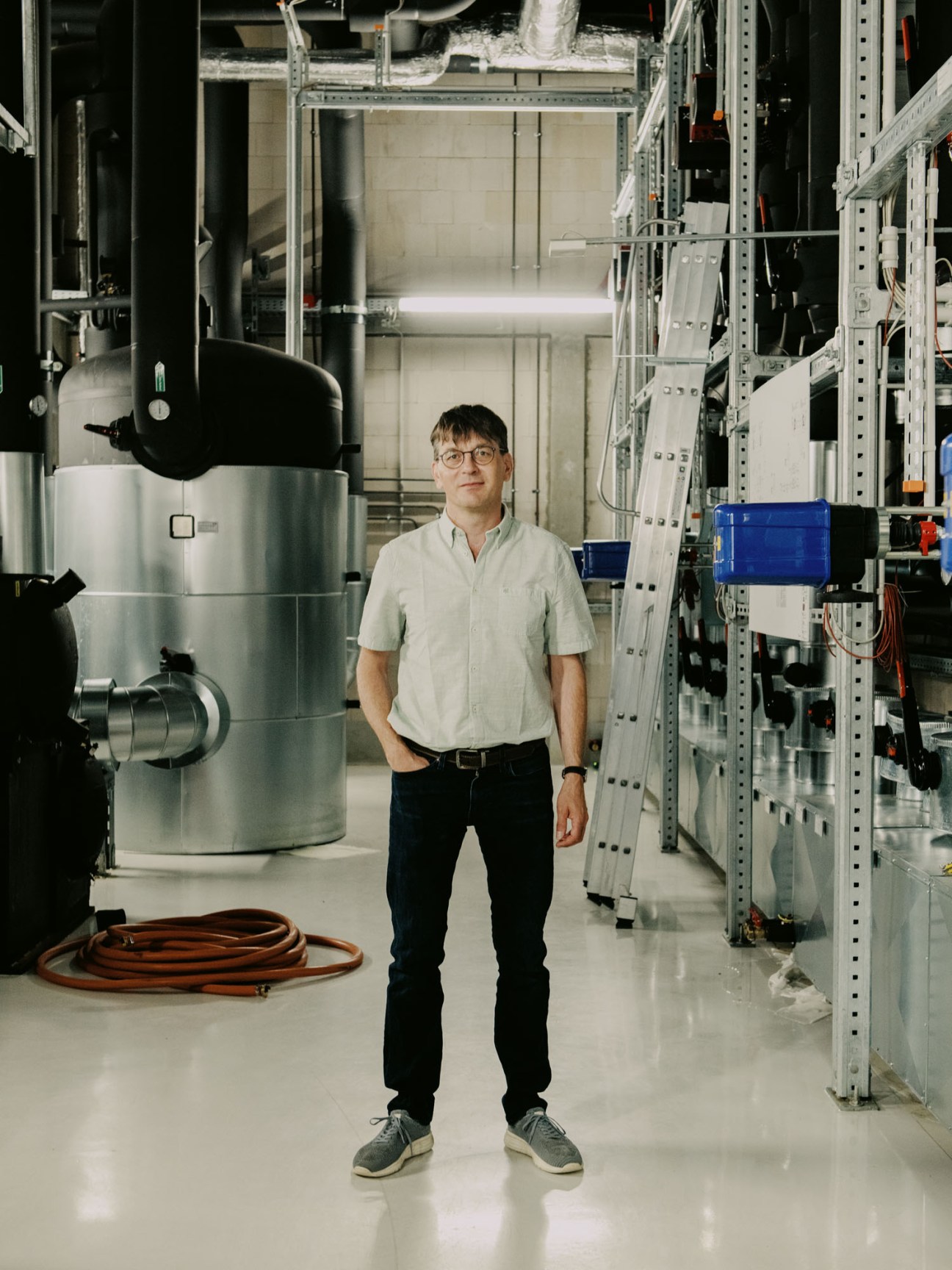 Mike Bommer standing in server room with industrial equipment and metal shelving