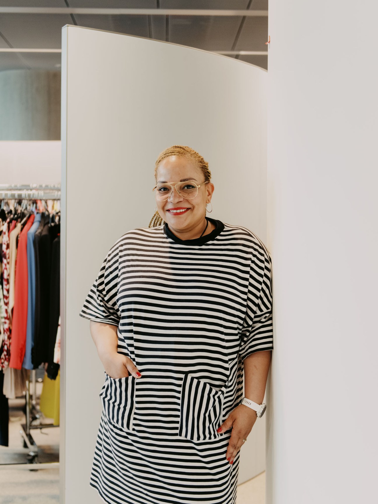 Woman in striped black and white outfit organizing clothing in wardrobe area