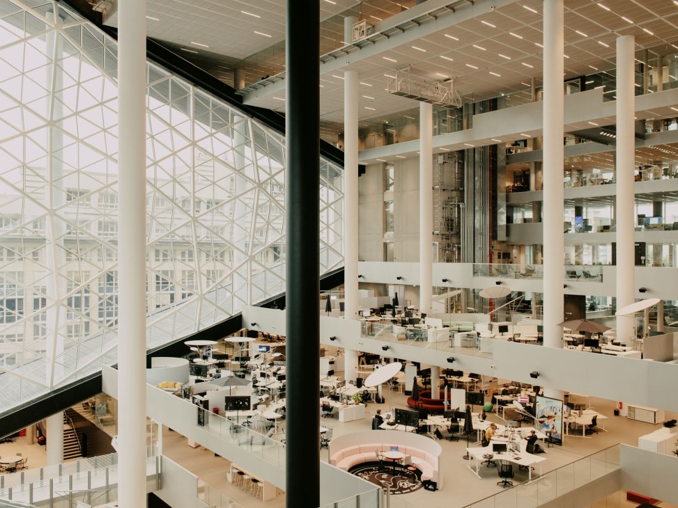 Large open-plan office space with glass atrium and modern workstations