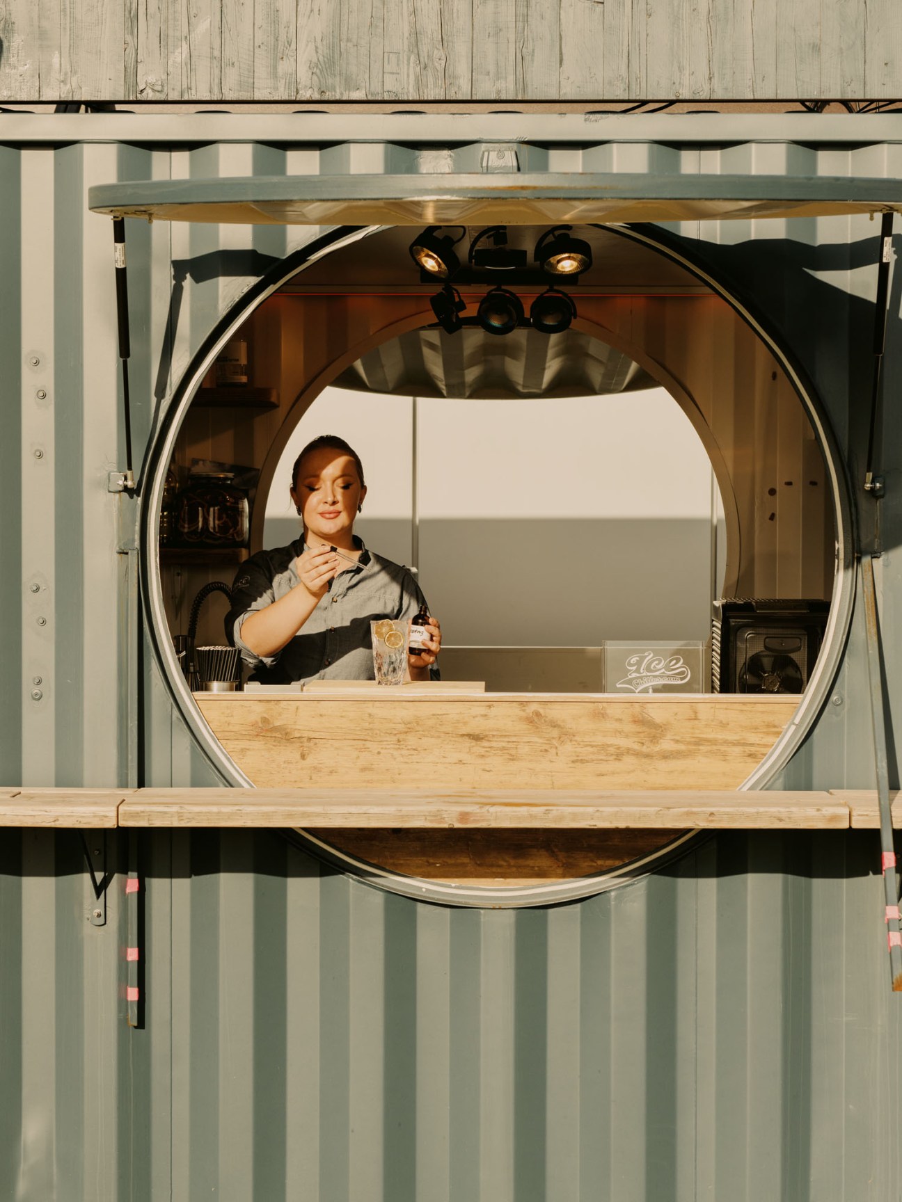 Woman preparing cocktail with rhubarb ingredients at rooftop bar