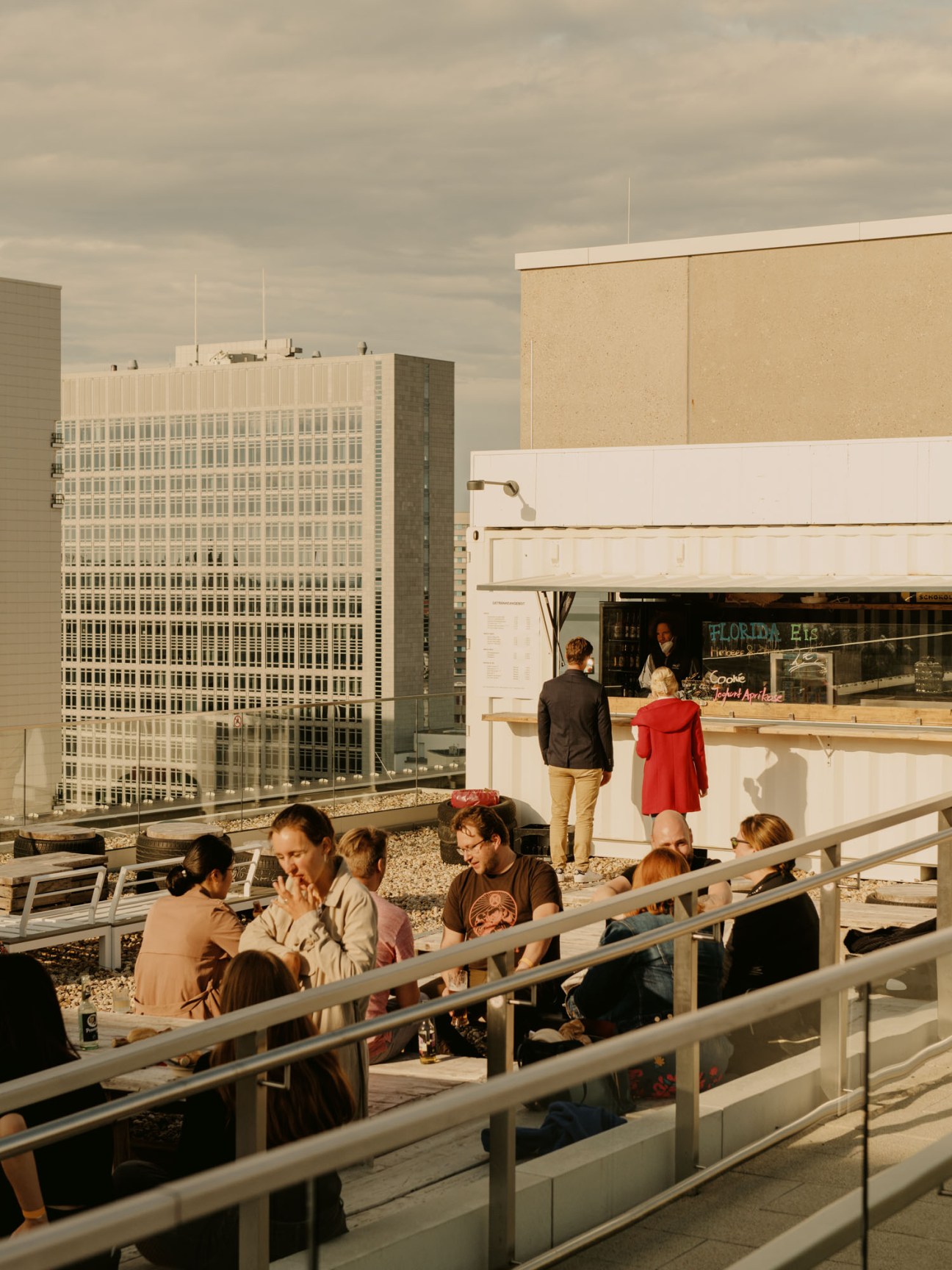 People enjoying drinks and German currywurst on rooftop terrace