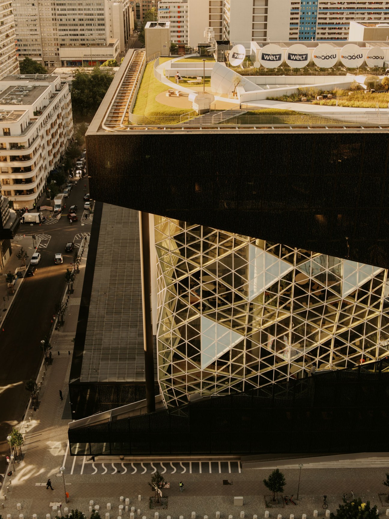 Aerial view of modern building with distinctive honeycomb-patterned glass facade and rooftop terrace