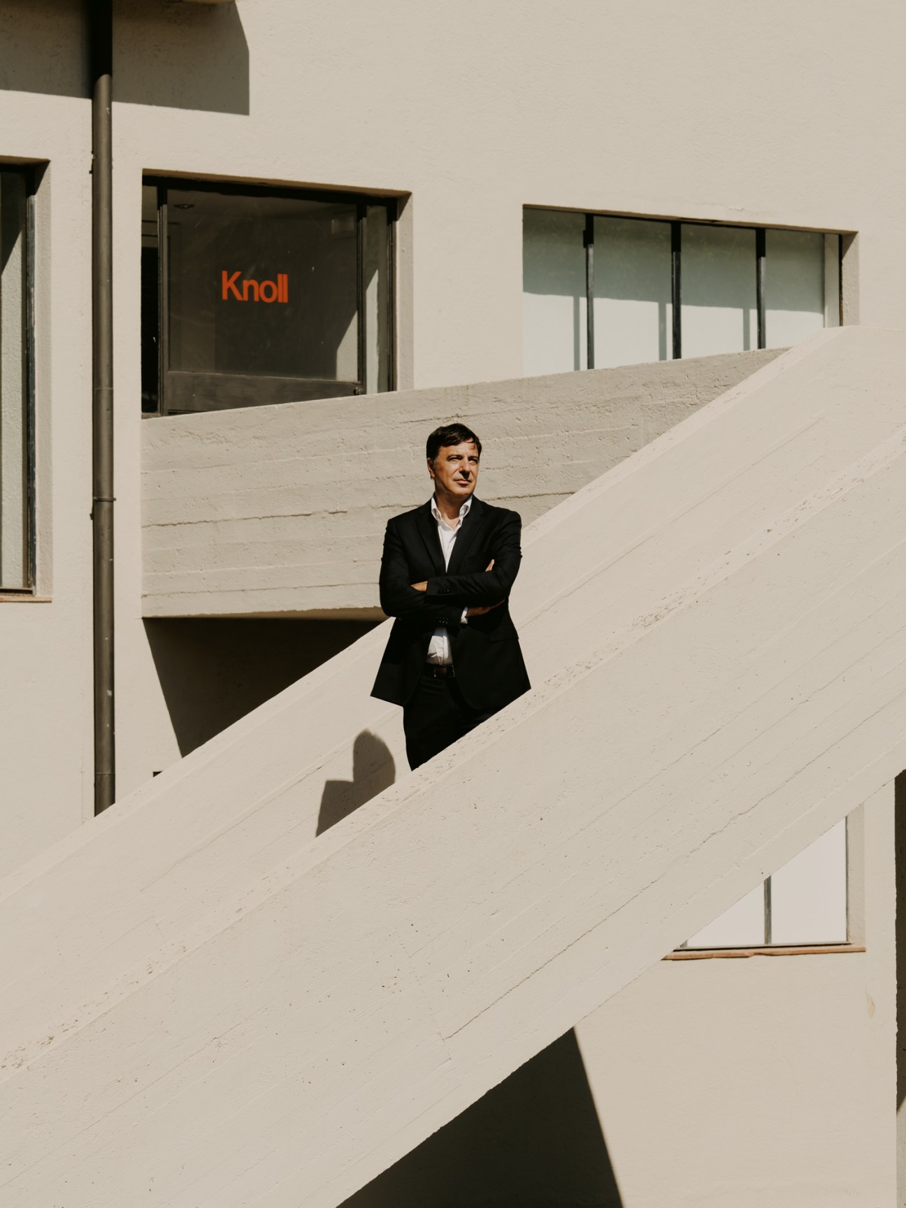 Demetrio Apolloni, president of Knoll Europe, in business attire standing on white concrete steps