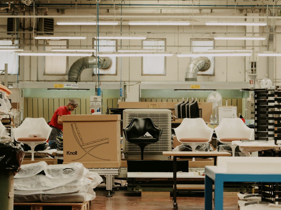 Factory finishing line with workers and furniture pieces in production