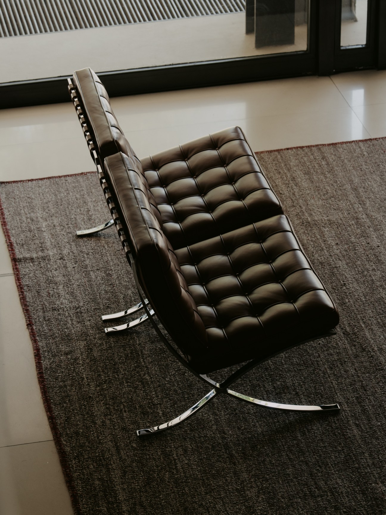 Barcelona chair by Mies van der Rohe with black leather tufted upholstery and chrome steel frame