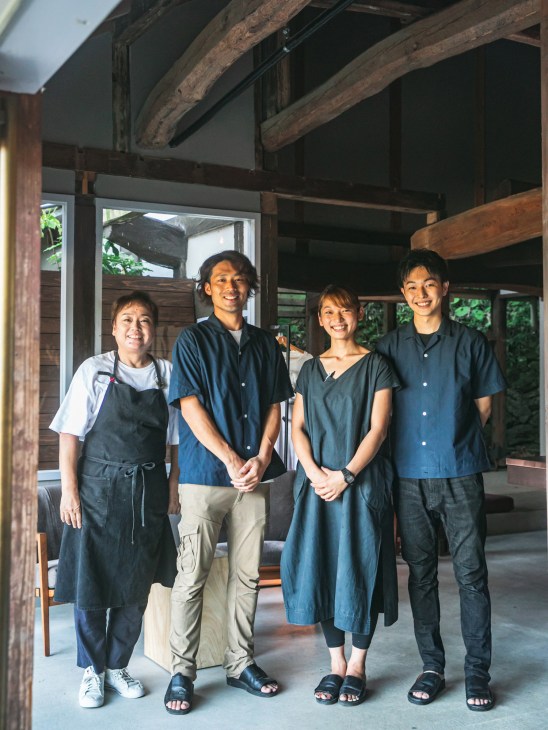 Shiho Umemori and staff members standing together inside Ume inn with exposed wooden beams.