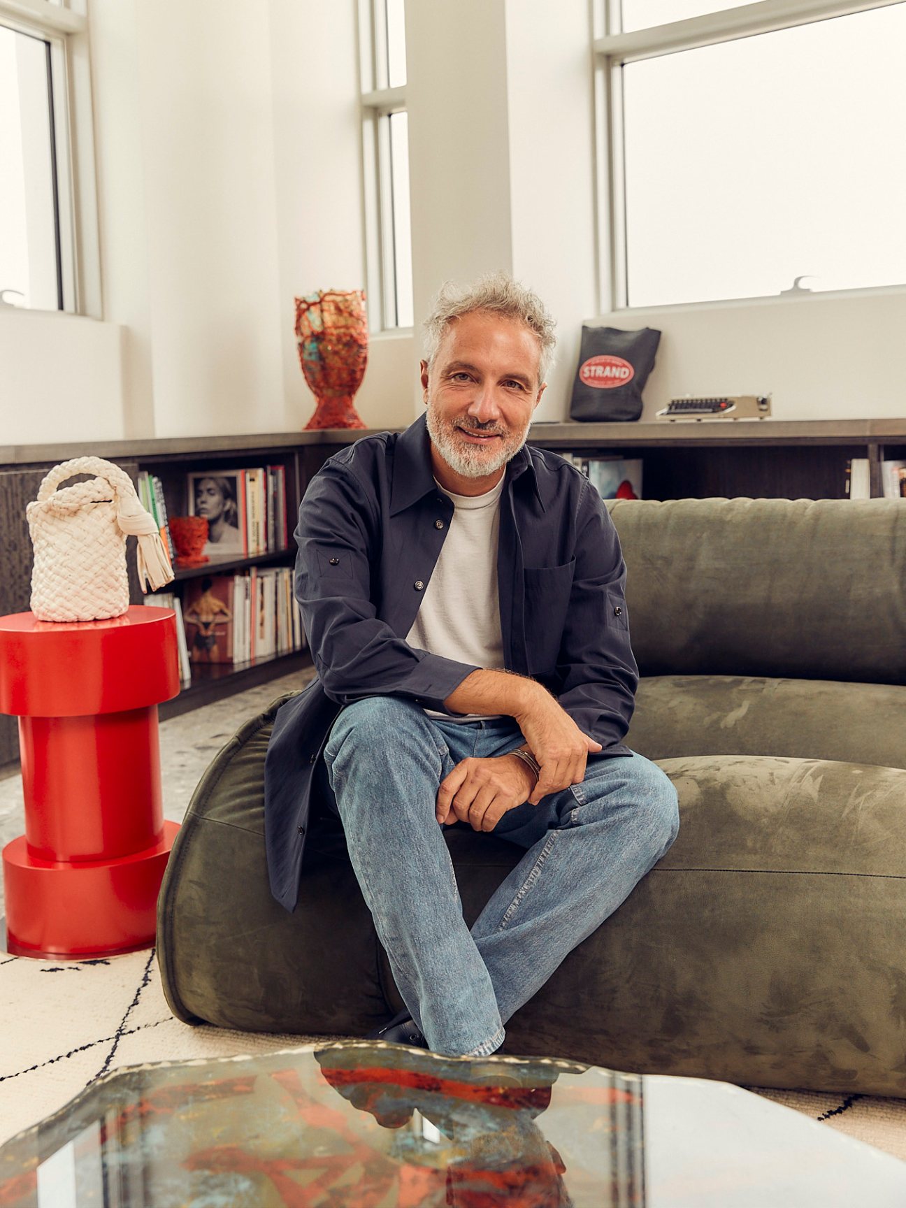 Leo Rongone, CEO of Bottega Veneta, sits on a grey sofa in his Milan office.