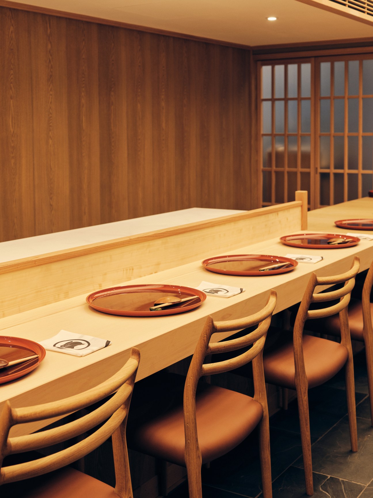 Interior of Roketsu restaurant showing wooden dining counter with place settings and traditional Japanese design