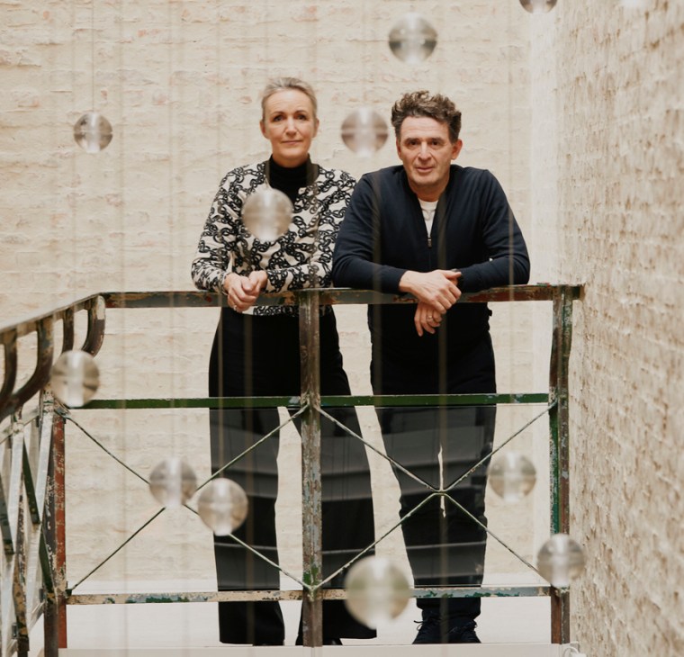 Almut Grüntuch-Ernst and Armand Grüntuch standing on metal platform in converted prison building