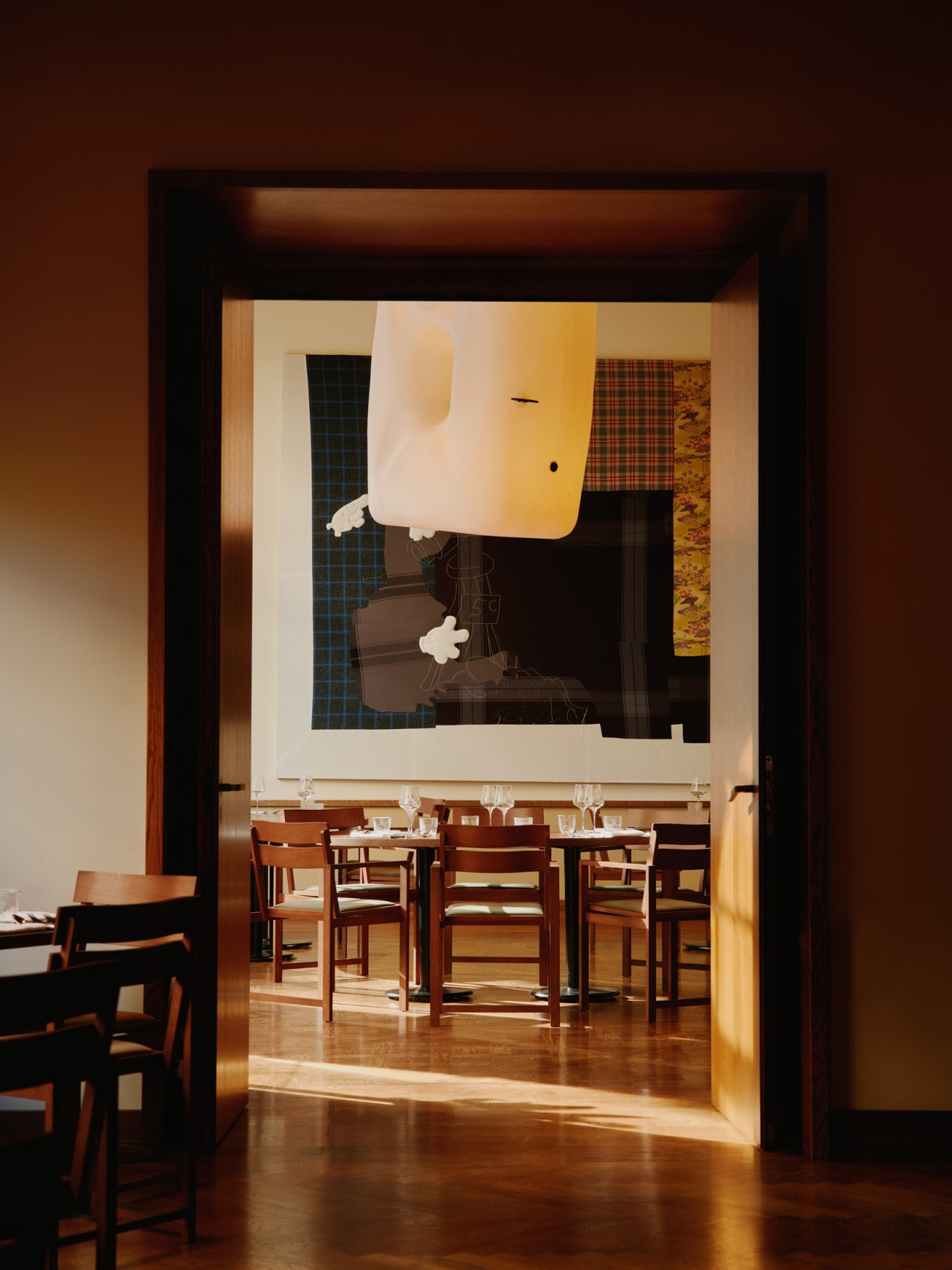 Restaurant Dóttir at Château Royal Berlin with wooden dining furniture and contemporary art on walls