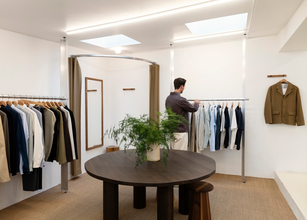 Minimalist interior of Another Aspect Copenhagen store with clothing racks, round table and clean design