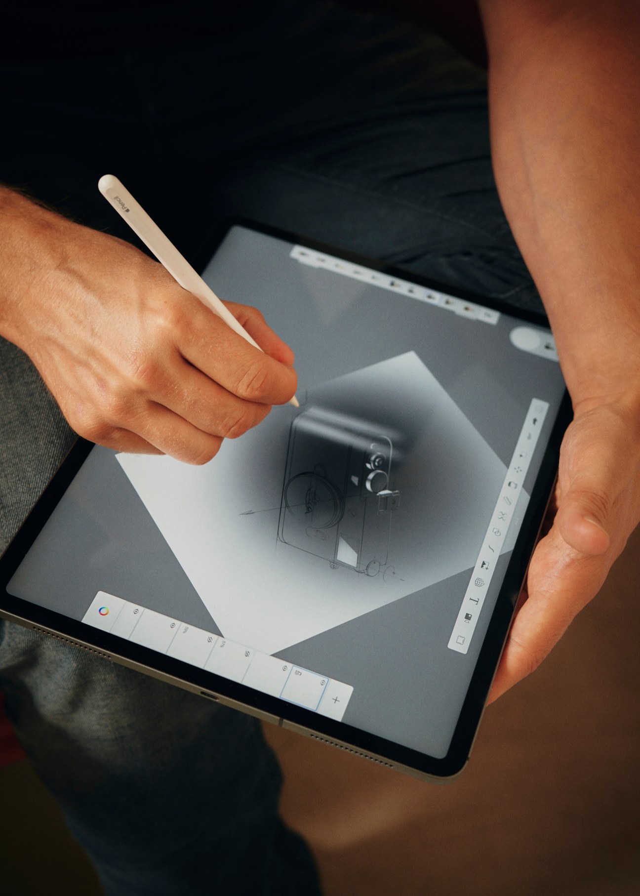 Person using stylus to sketch camera design on tablet screen