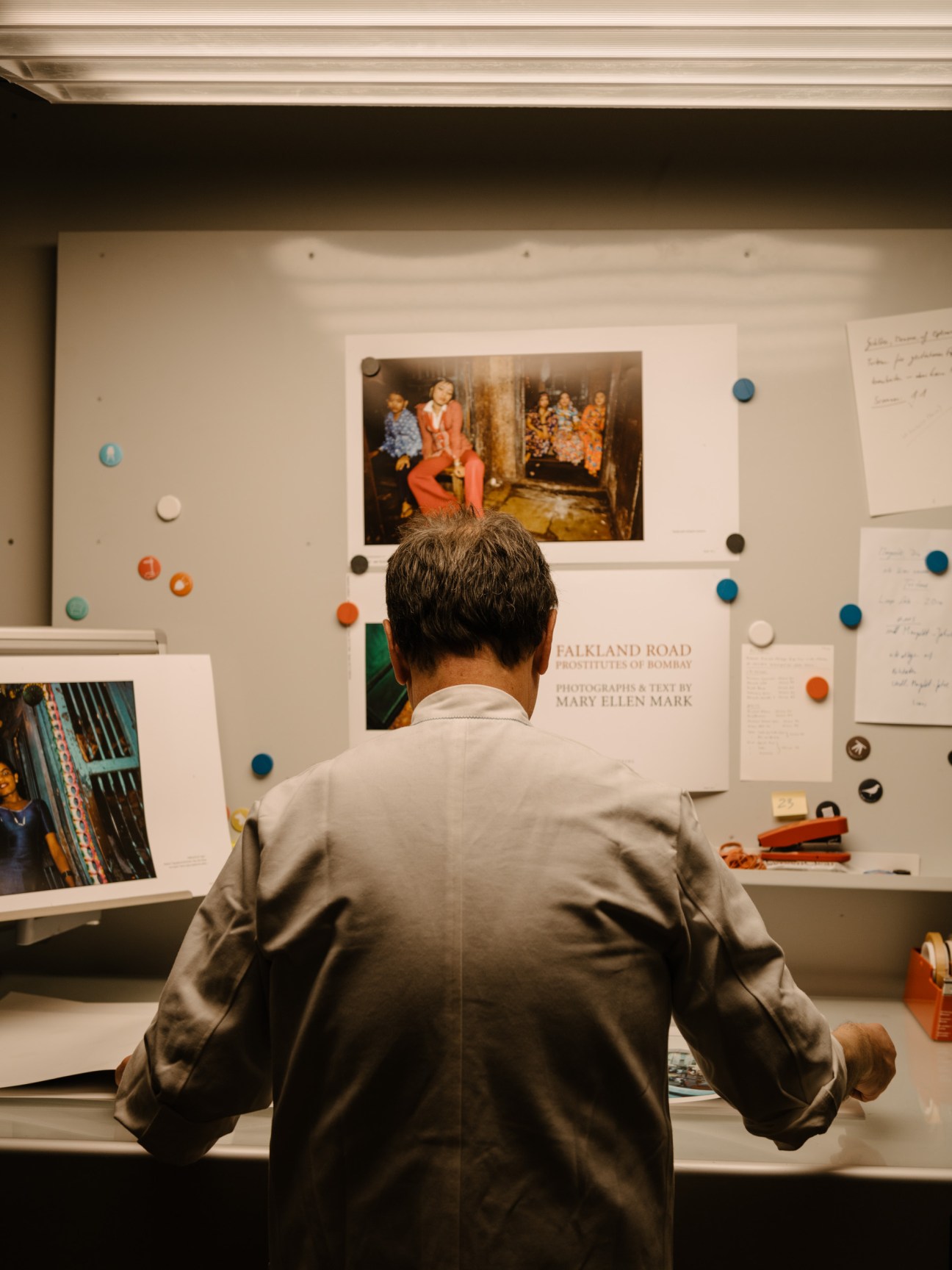 Gerhard Steidl examines proofs and materials for Mary Ellen Mark's 'Falkland Road' pinned to a design board.