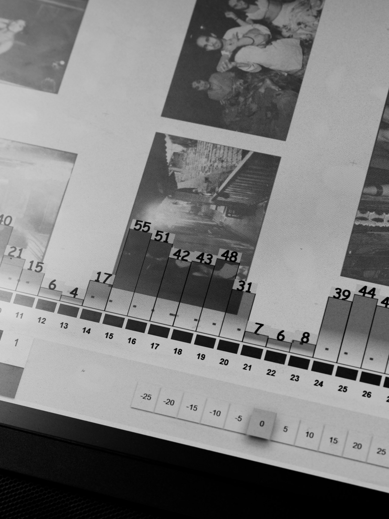 Black and white photograph with printed pages and a grayscale density strip with numbered gradations for quality control.