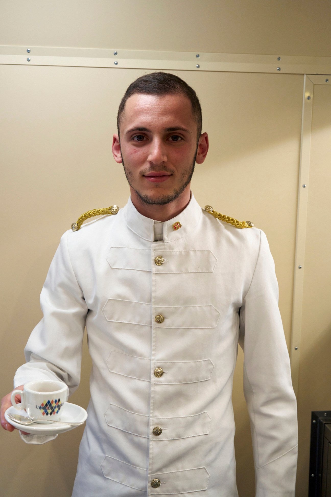 Server preparing coffee service with silver serving tray aboard vintage train