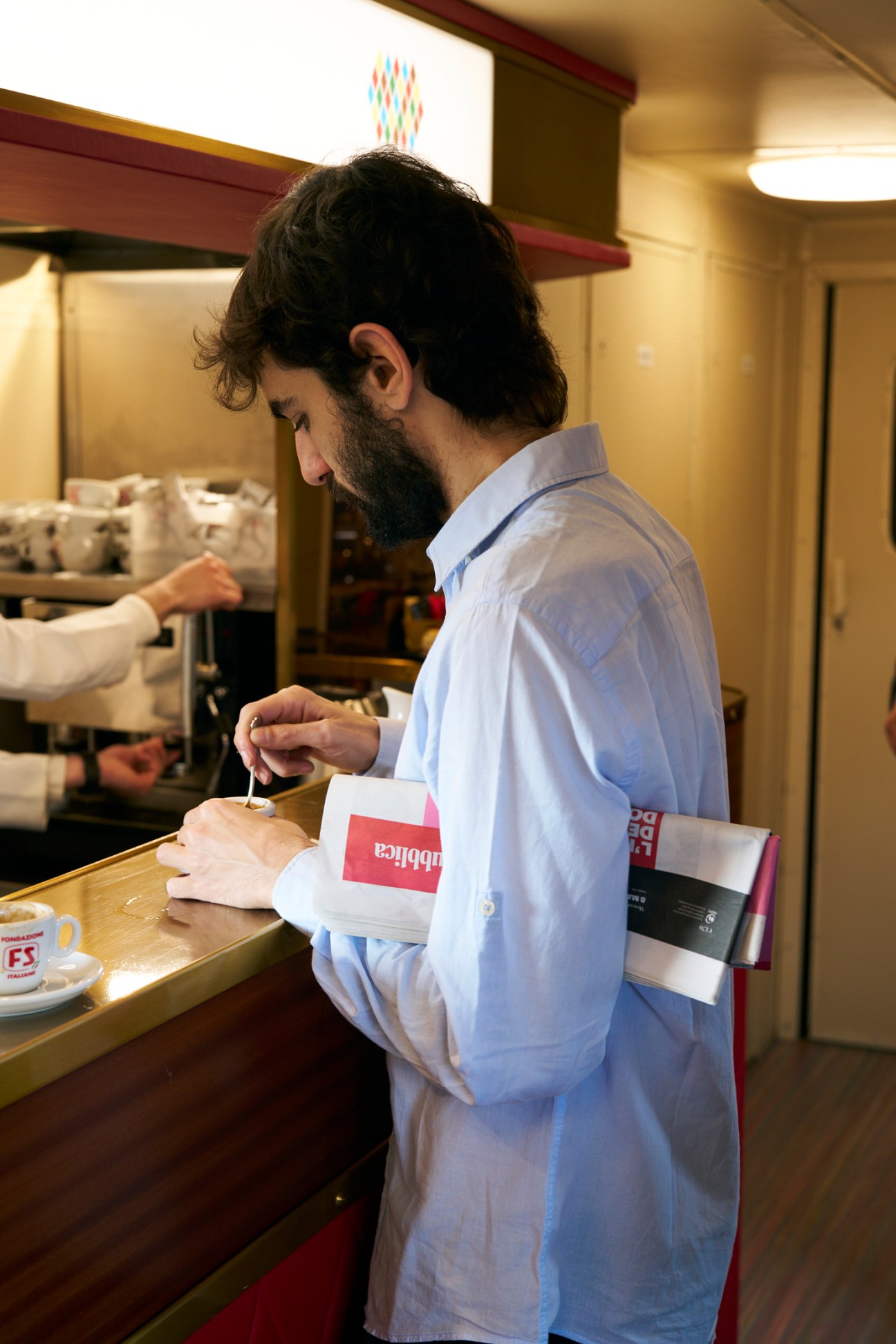 Passengers reading newspapers aboard the L'Arlecchino train