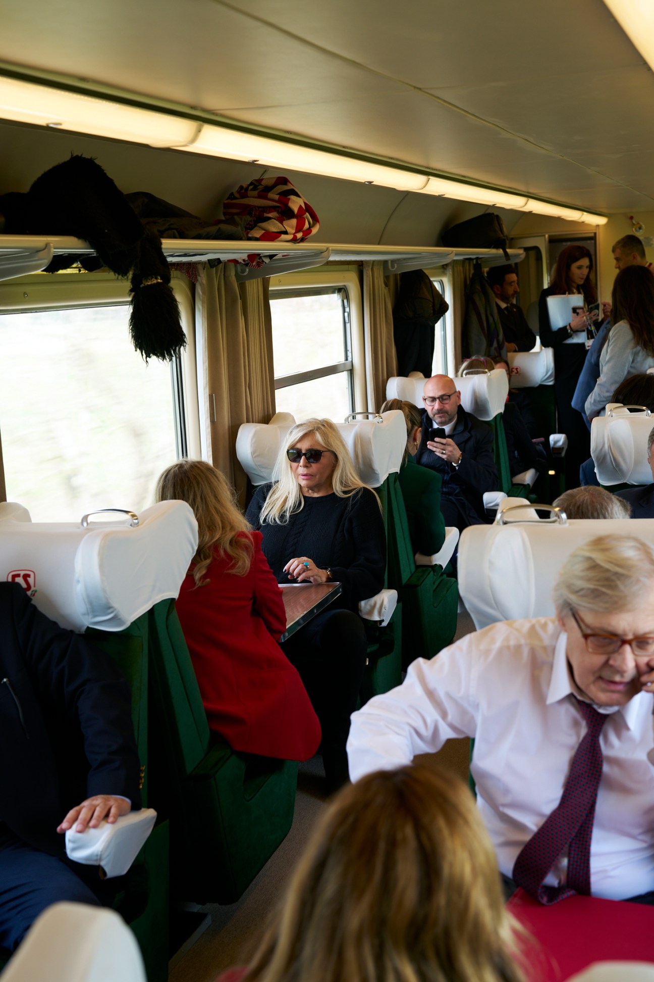 TV presenter Mara Venier wearing sunglasses while deputy culture minister Vittorio Sgarbi makes a phone call