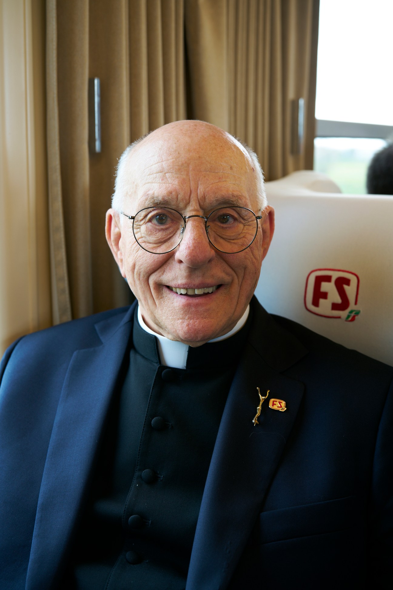 Monsignor Professor Liberio Andreatta, President of Fondazione FS, seated aboard the train