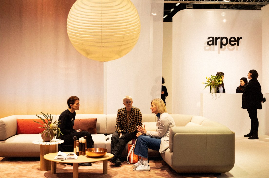 Modern furniture showroom with white sofas, wooden coffee table, large paper lantern and Arper brand signage