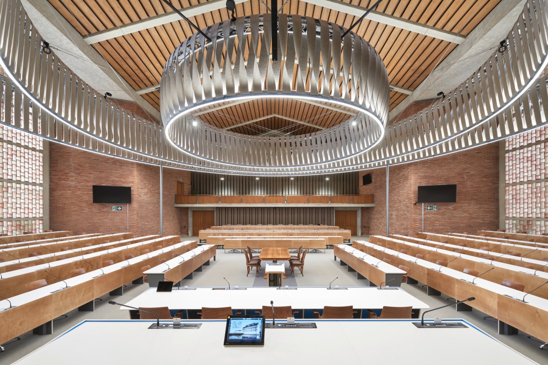 Interior of Bullingerkirche church converted to parliamentary chamber with horseshoe seating arrangement and modern lighting