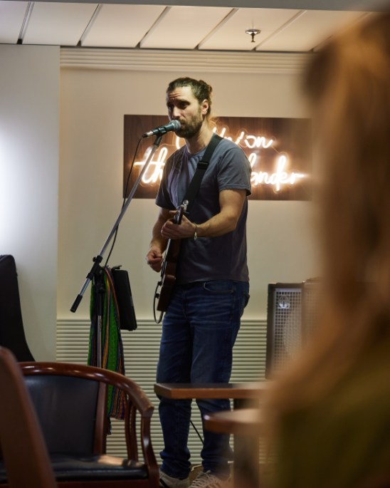 Musician performing on the Interislander ferry deck with passengers watching