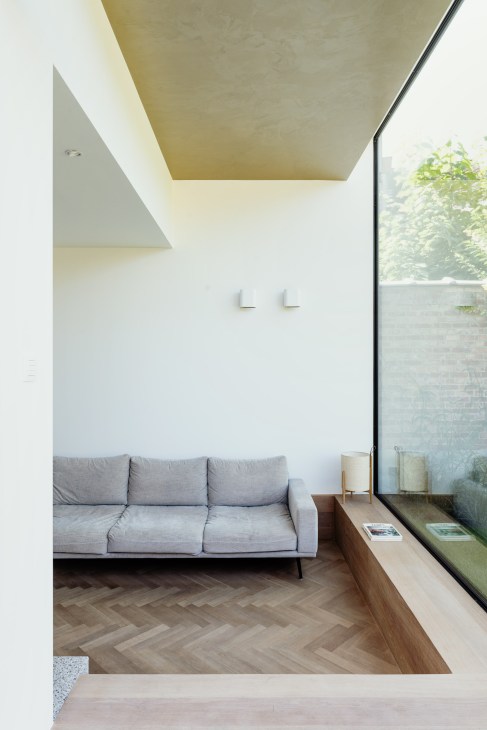 Sunken seating area designed by Studio Ambacht featuring built-in benches and modern furnishings