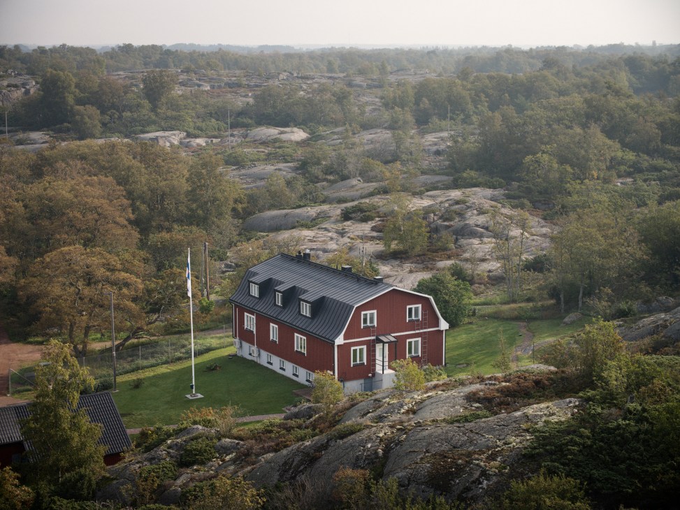 Border guard station building on a rocky coastline with boats moored in the harbor