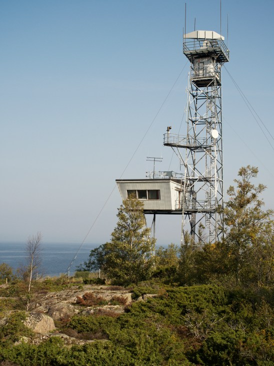 White cylindrical radar tower structure against a cloudy sky