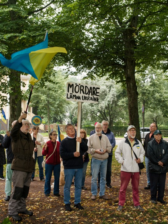 Group of people holding protest signs outside a building