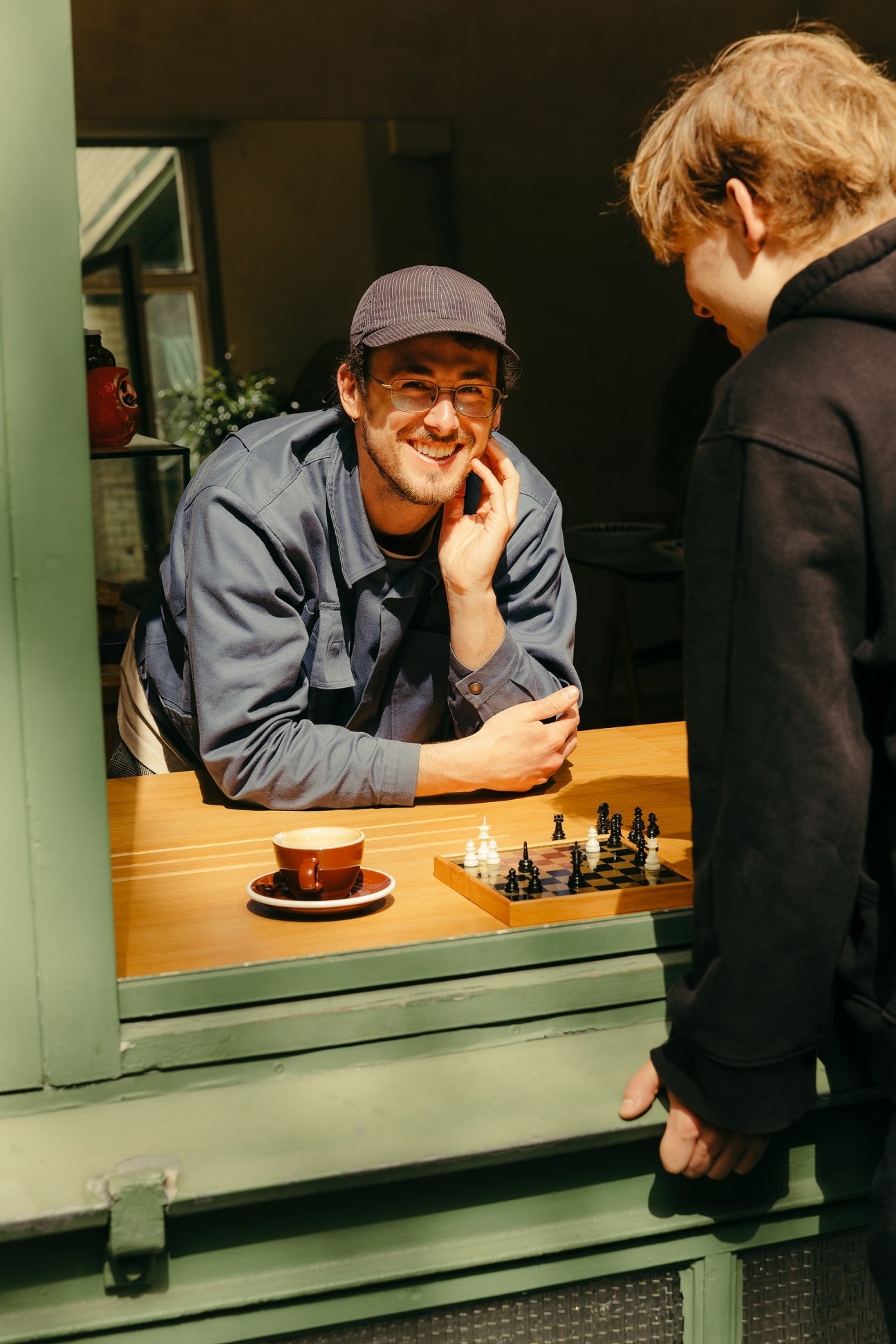 Barista playing chess with a customer at Toki café counter on a Sunday morning