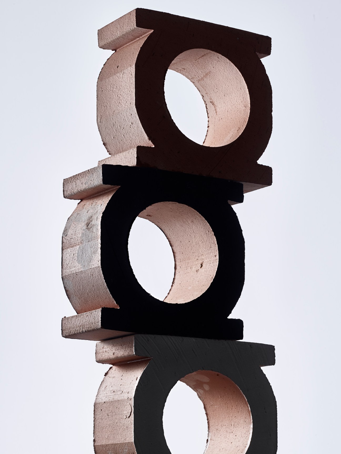Stack of three terracotta Jali bricks with circular openings, showing modular perforated design by Patricia Urquiola
