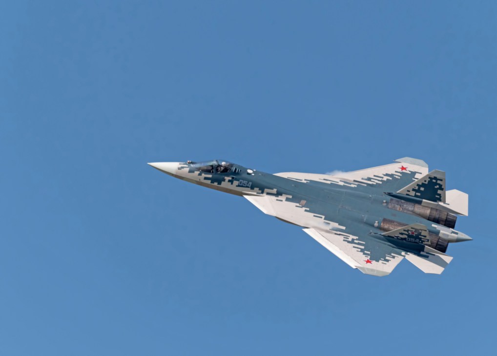 Russian stealth fighter aircraft Su-57 flying against clear blue sky