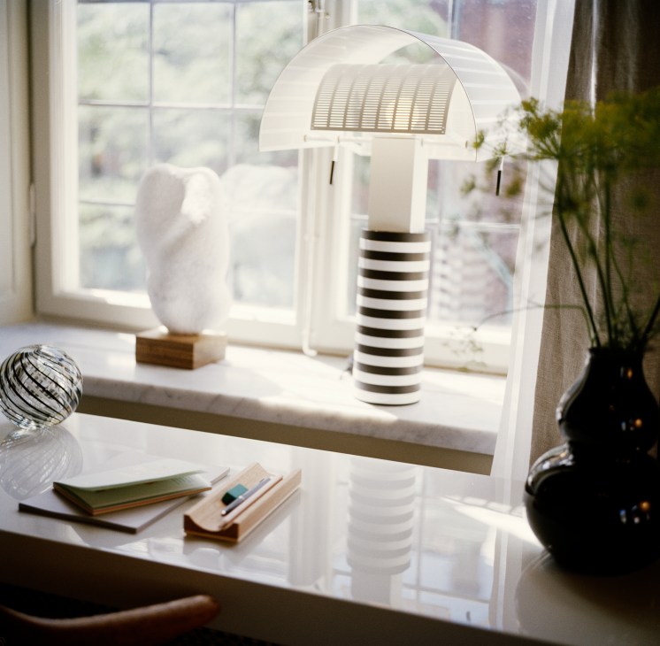 Modern desk setup with distinctive table lamp and minimalist design elements
