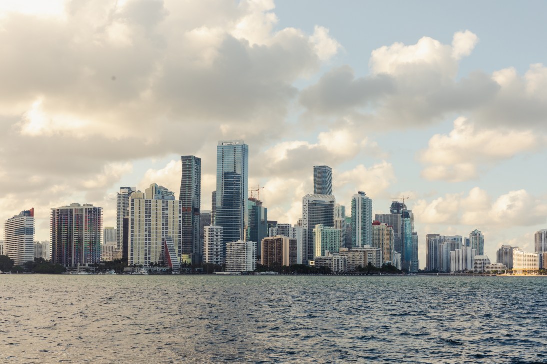 Miami skyline with high-rise buildings and construction cranes viewed from across the water