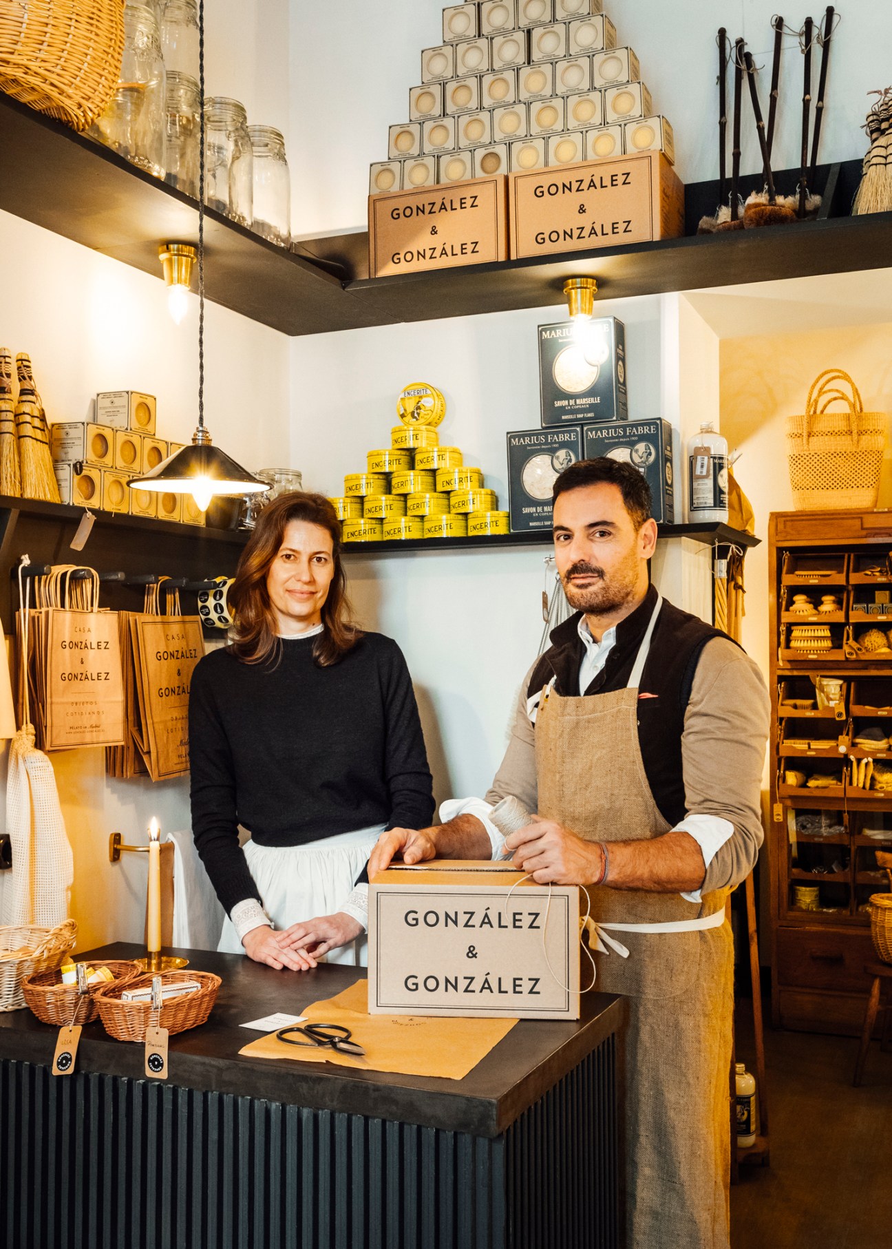 María Rosa and Javier González standing behind their store counter with González & González branded products