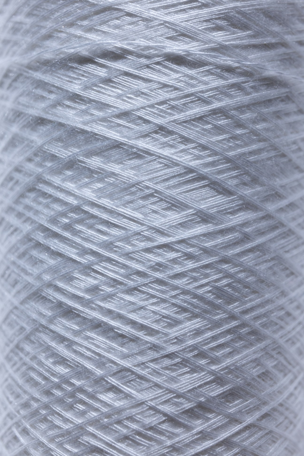 Close-up view of various white and gray textile fiber samples showing different textures and weave patterns