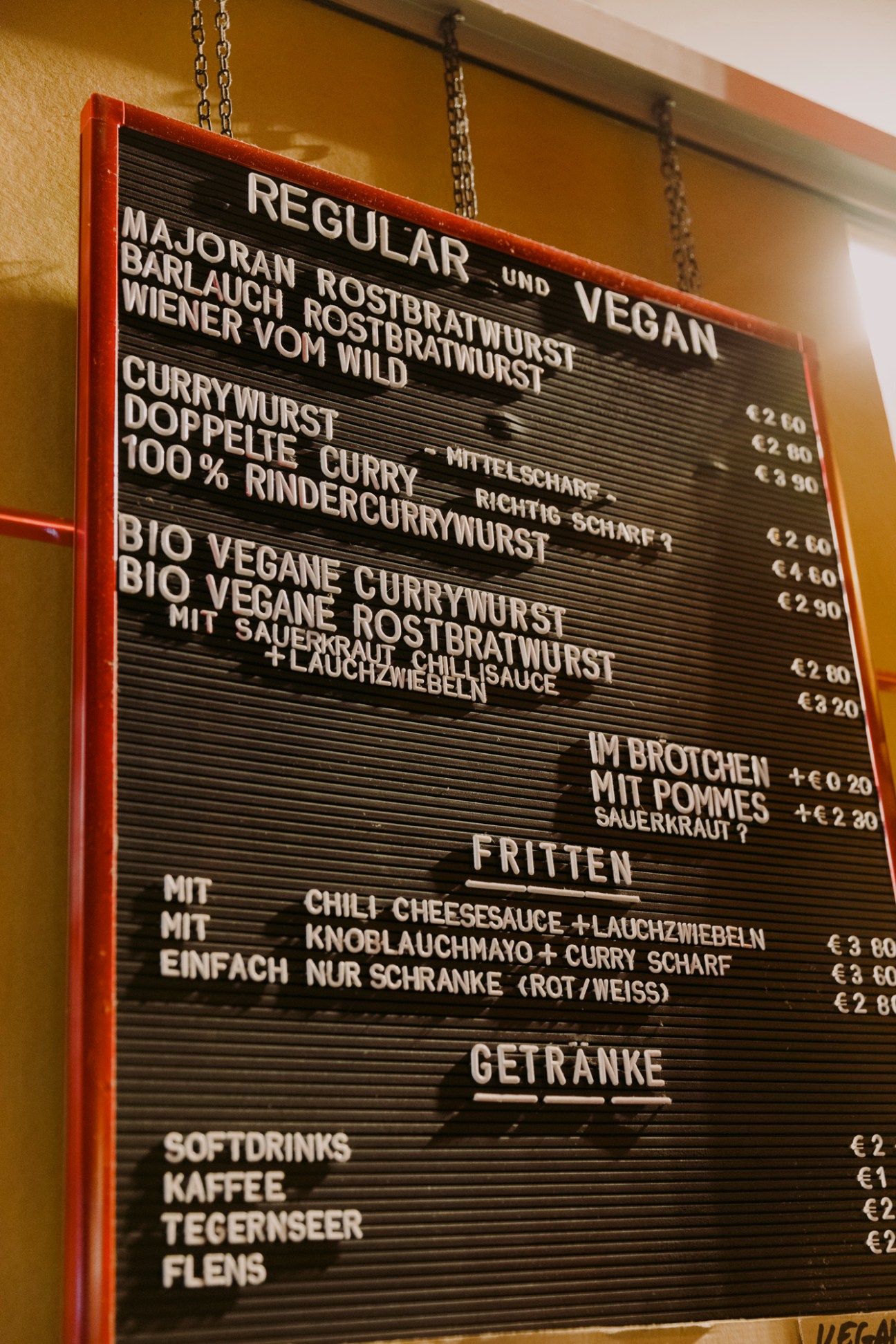 Menu board showing regular and vegan currywurst options with prices in German
