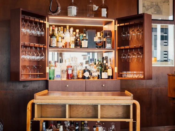 Bentwood birch bar trolley from 1936 at Savoy restaurant in Helsinki with built-in bar cabinet behind