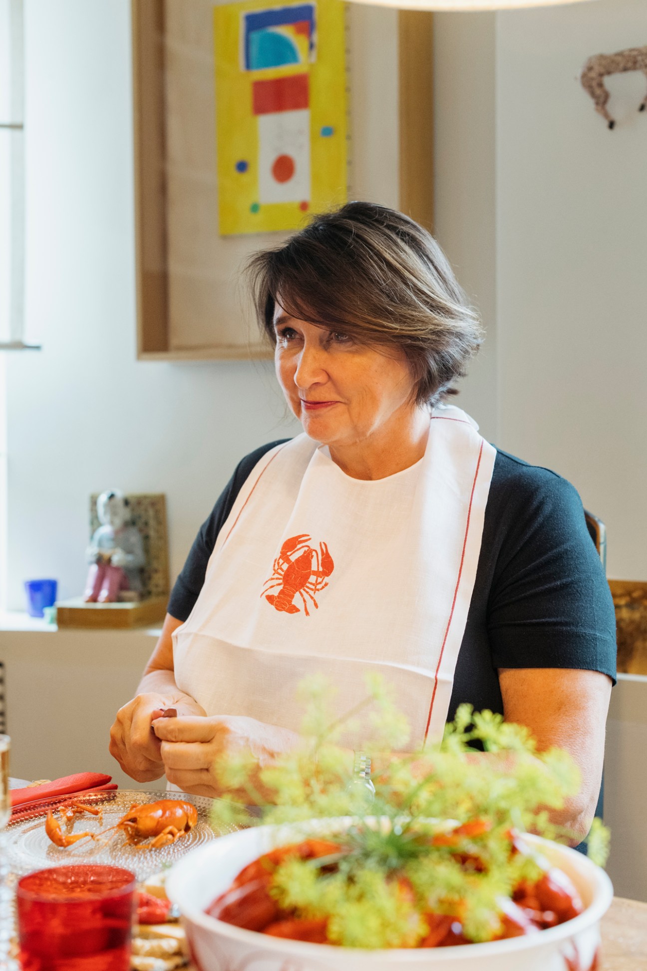 Rafaela Seppälä in her kitchen wearing a lobster-print apron while preparing food