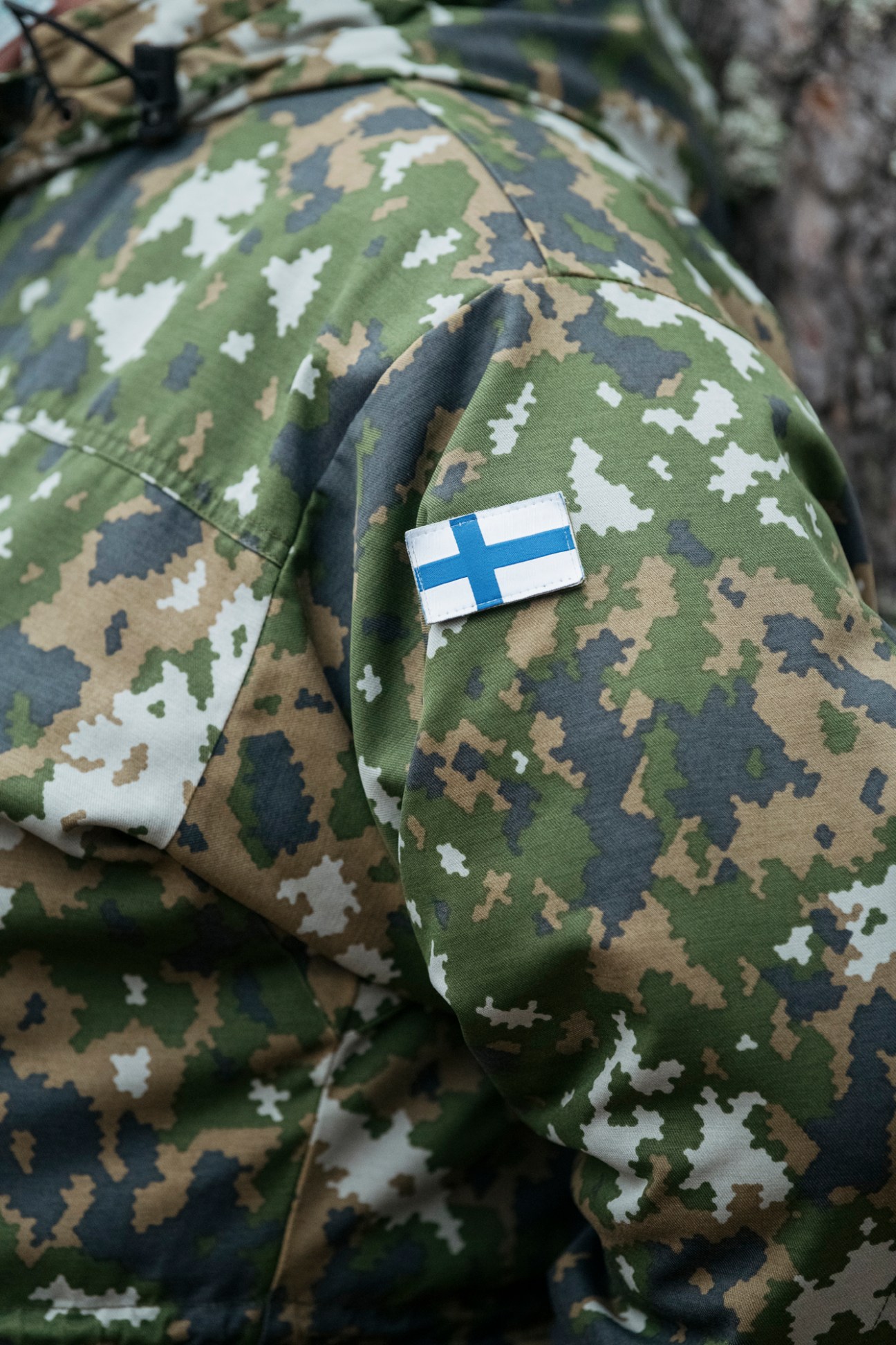 Close-up of M05 military uniform fabric with Finnish flag patch showing blue cross on white background